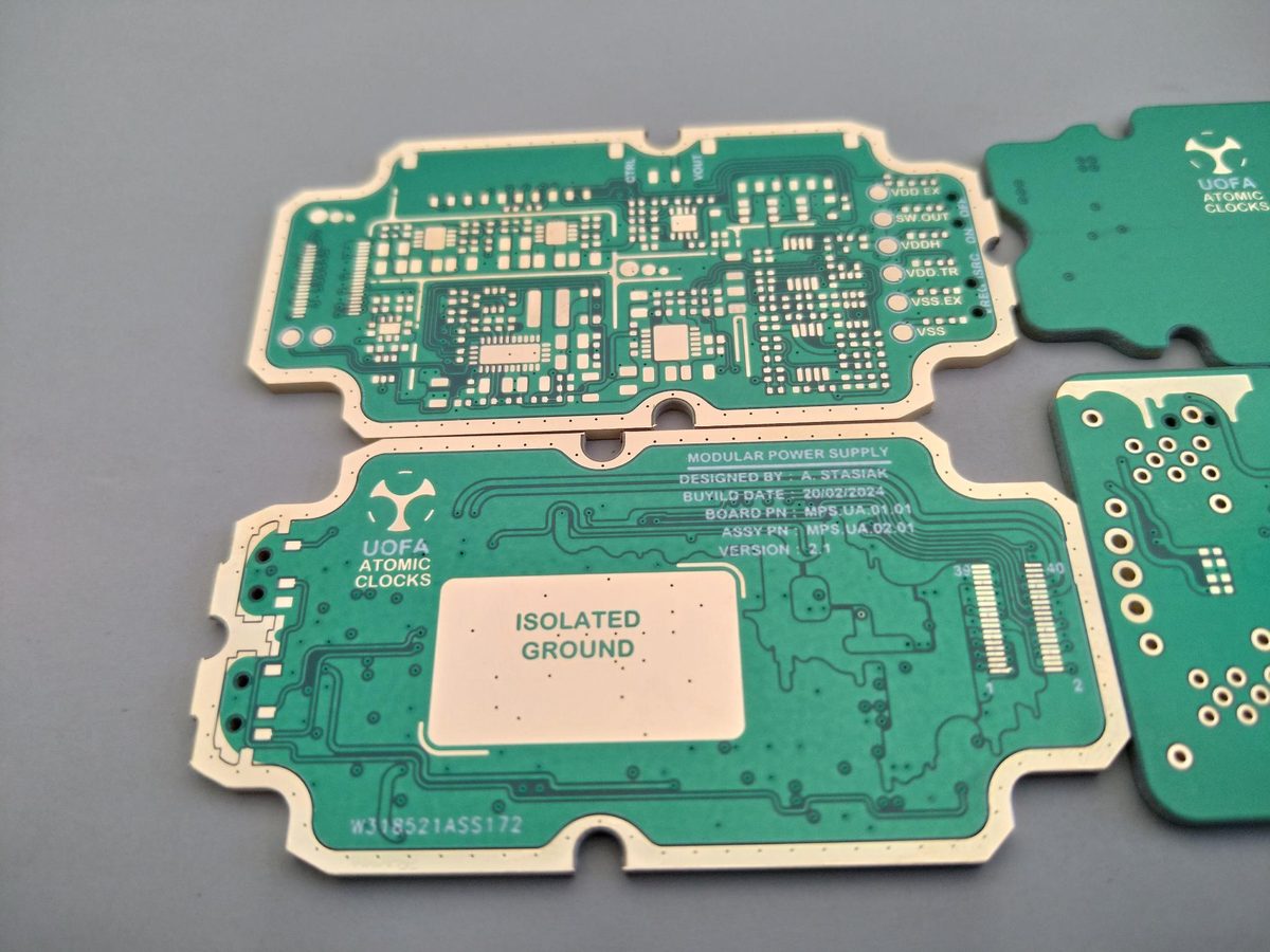 Close-up of a module silkscreened MODULAR POWER SUPPLY, DESIGNED BY A. STASIAK, with a LOCAL ATOMIC CLOCKS logo and a large area marked ISOLATED GROUND.