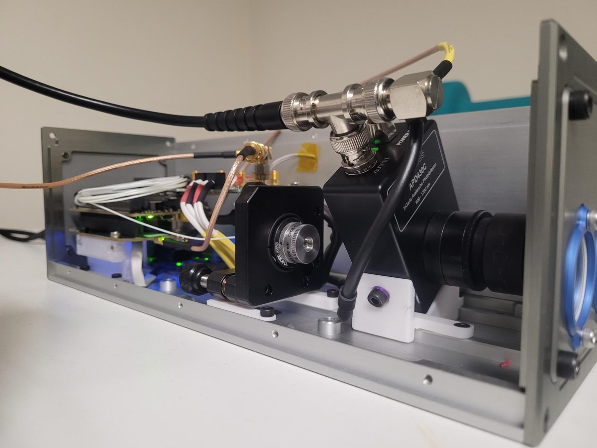 An aluminium optical chassis with a lens barrel, mirror mount and the electronics mounted alongside.