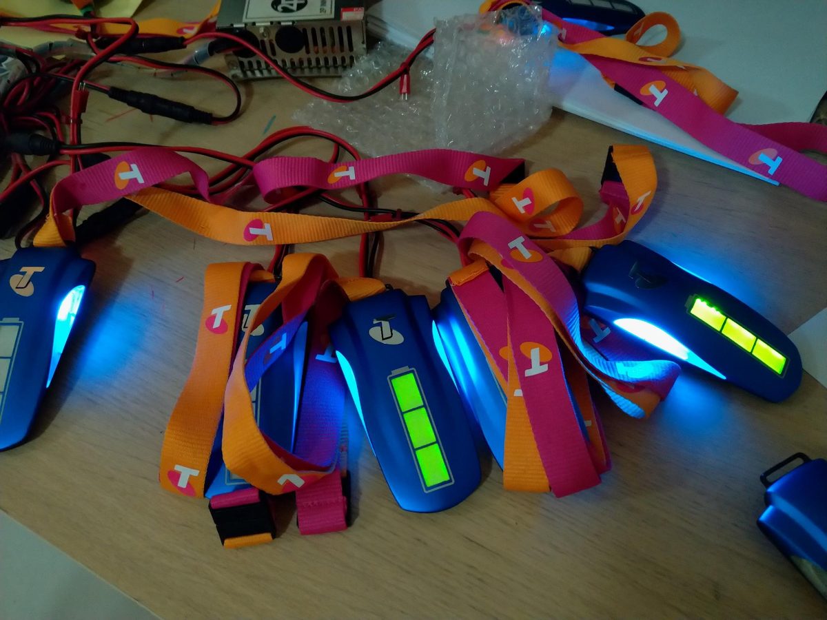 A pile of small blue moulded RF token devices on coloured lanyards, each showing a green indicator bar.